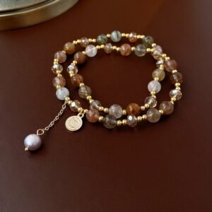 Natural stone beaded bracelet with gold-tone spacer beads and pearl-style charm