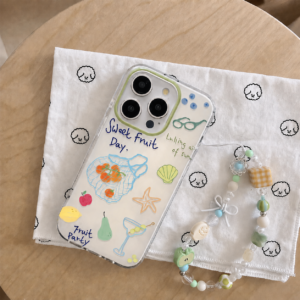 Sweet Fruit Day iPhone case and pastel beaded phone charm flat lay on white cloth